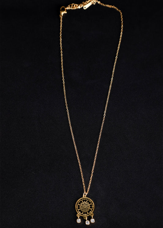 A gold-toned dreamcatcher necklace with a detailed web design pendant and small dangling clear beads, displayed against a solid black background.