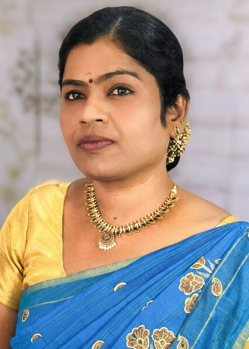 A woman wearing a gold jewelry plated palakka necklace and matching earrings.