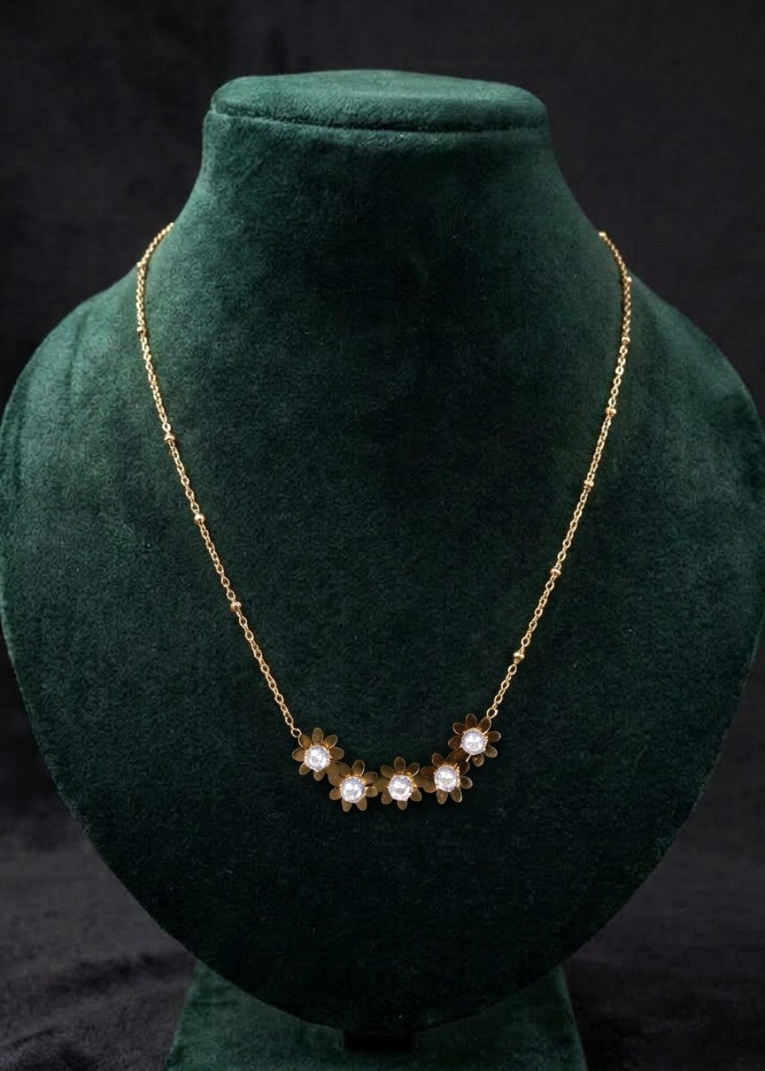 Jenny floral rhinestone necklace laid on cream fabric, showing the gold-toned beaded chain and extension clasp.