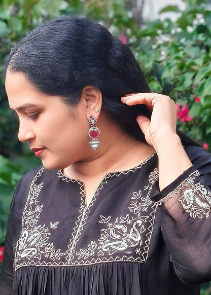 A woman wearing a silver-toned earrings