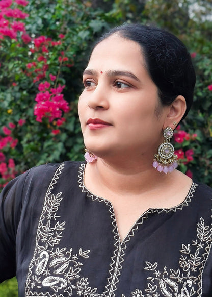 A woman wearing a lilac chandbali earrings