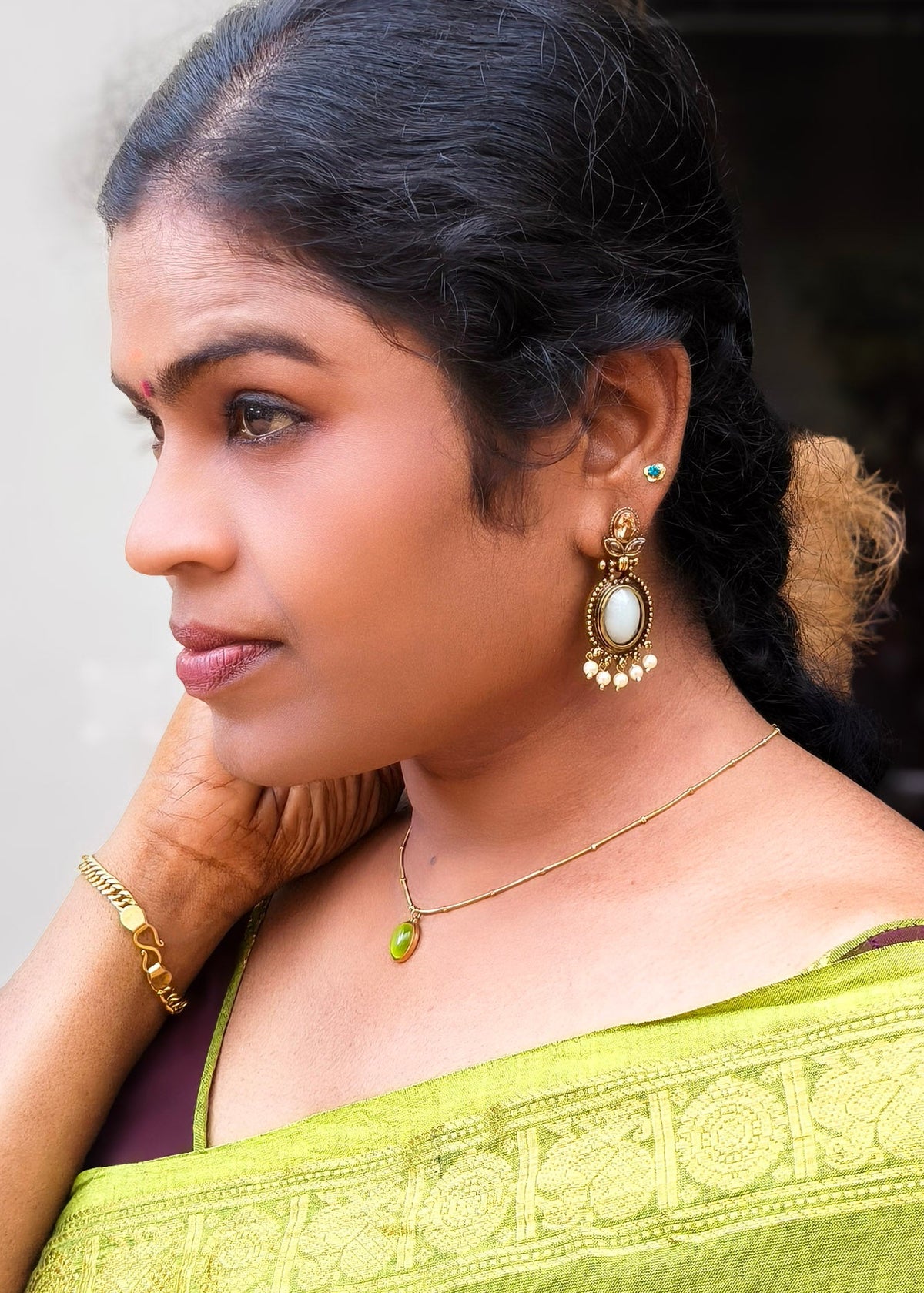 A woman in profile wearing gold-toned traditional Indian jewelry