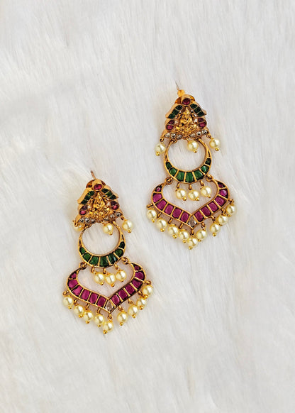A pair of gold-toned traditional Indian chandelier earrings decorated with green and magenta enamel, set with small white pearls.