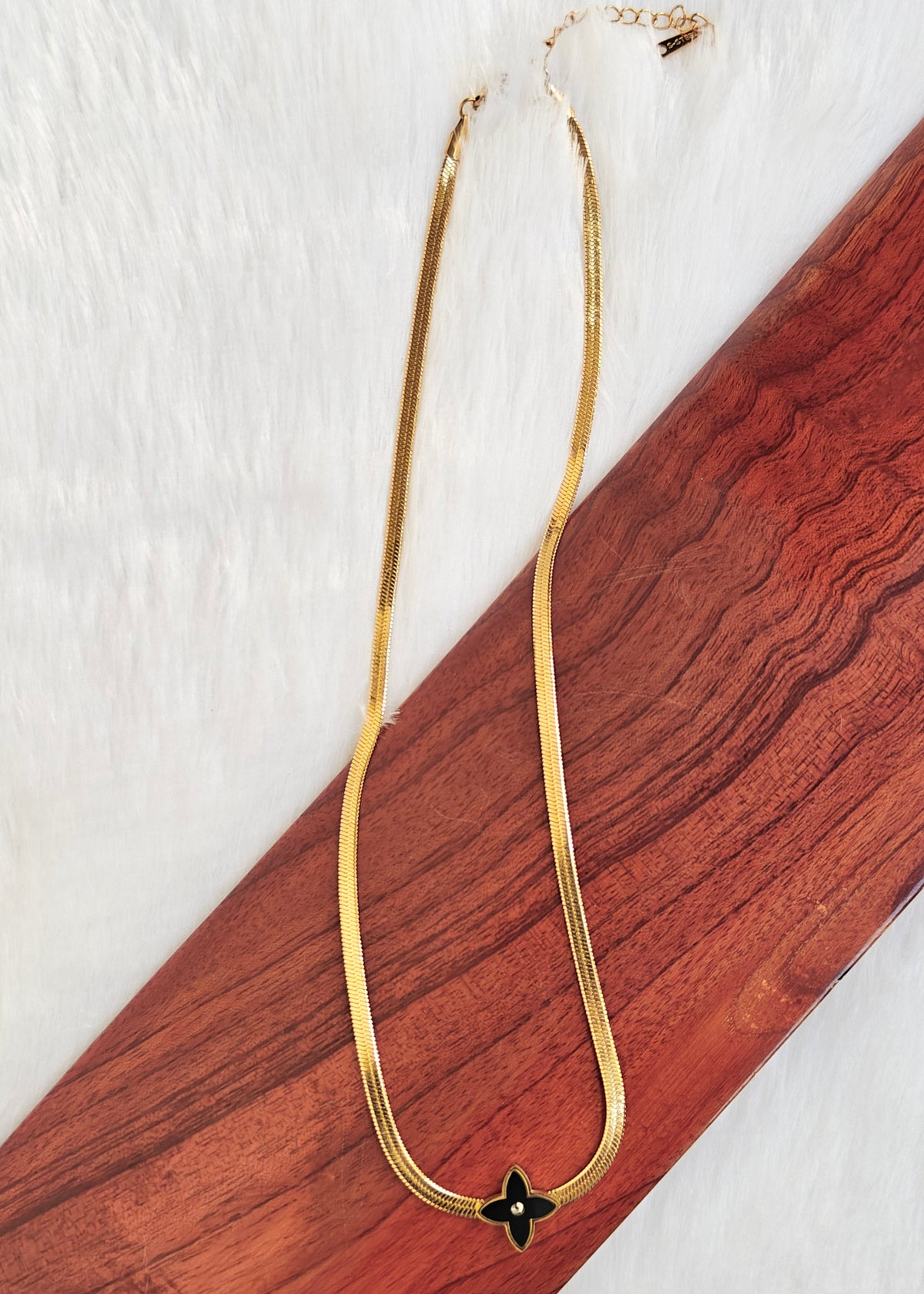 Anti tarnish gold snake chain necklace with a black enamel four-leaf clover pendant, 