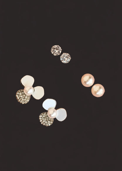 Three pairs of stud earrings. The earrings feature white faux pearls, clear rhinestone-covered round studs, and a cluster design combining white discs, clear rhinestones, and a pearl.