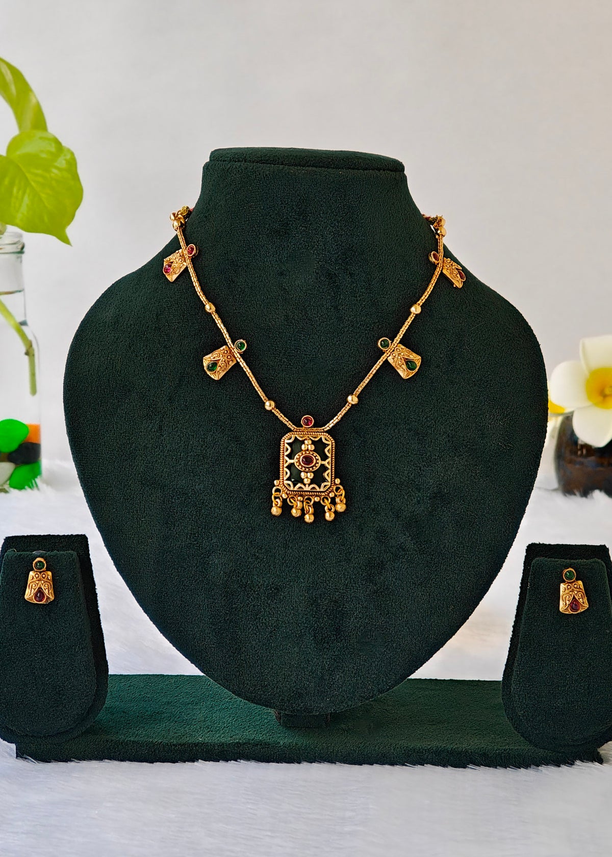 Antique type gold plated necklace set with green and red stone embellishments with green enamel pendant. 