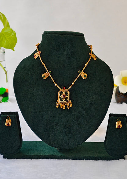 Antique type gold plated necklace set with green and red stone embellishments with green enamel pendant. 