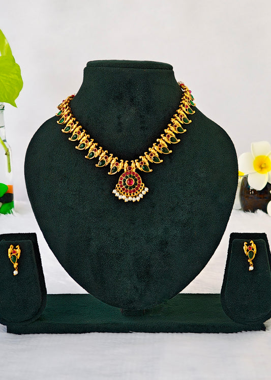 Gold-toned traditional necklace and matching earrings displayed on a black velvet jewelry bust against a white background.