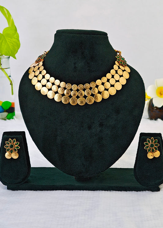 Gold coin necklace and matching flower earrings displayed on a black velvet jewelry bust and stand against a white background.