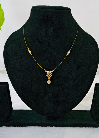 Haya fine-wire necklace with white pearl accents, a crystal lattice and teardrop charm on a black display