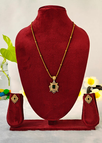 Gold necklace and matching earrings displayed on a dark red velvet jewelry bust set against a light background with decorative flowers.