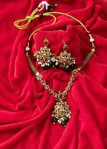 Vidya Lakshmi necklace set on red fabric, showing matching earrings, pearl clusters, green drops and adjustable tie cord.