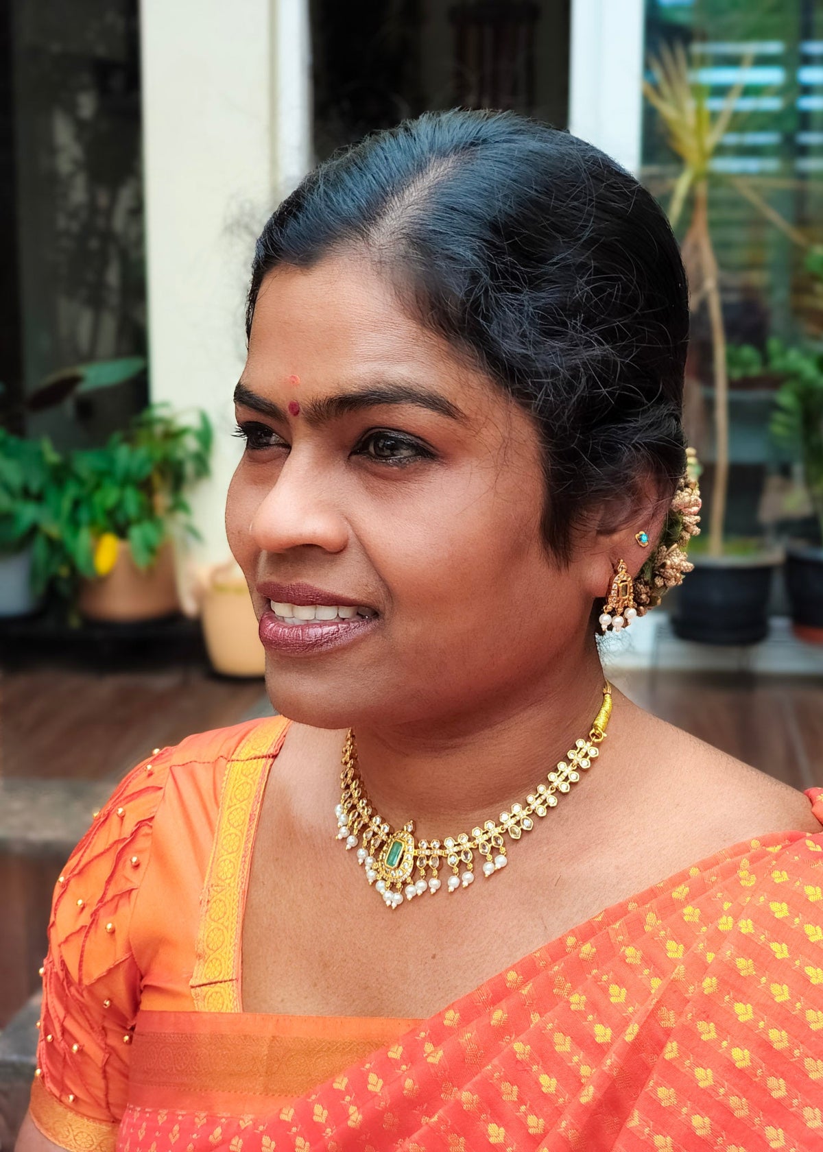 A woman wearing a matching gold necklace and earrings, 