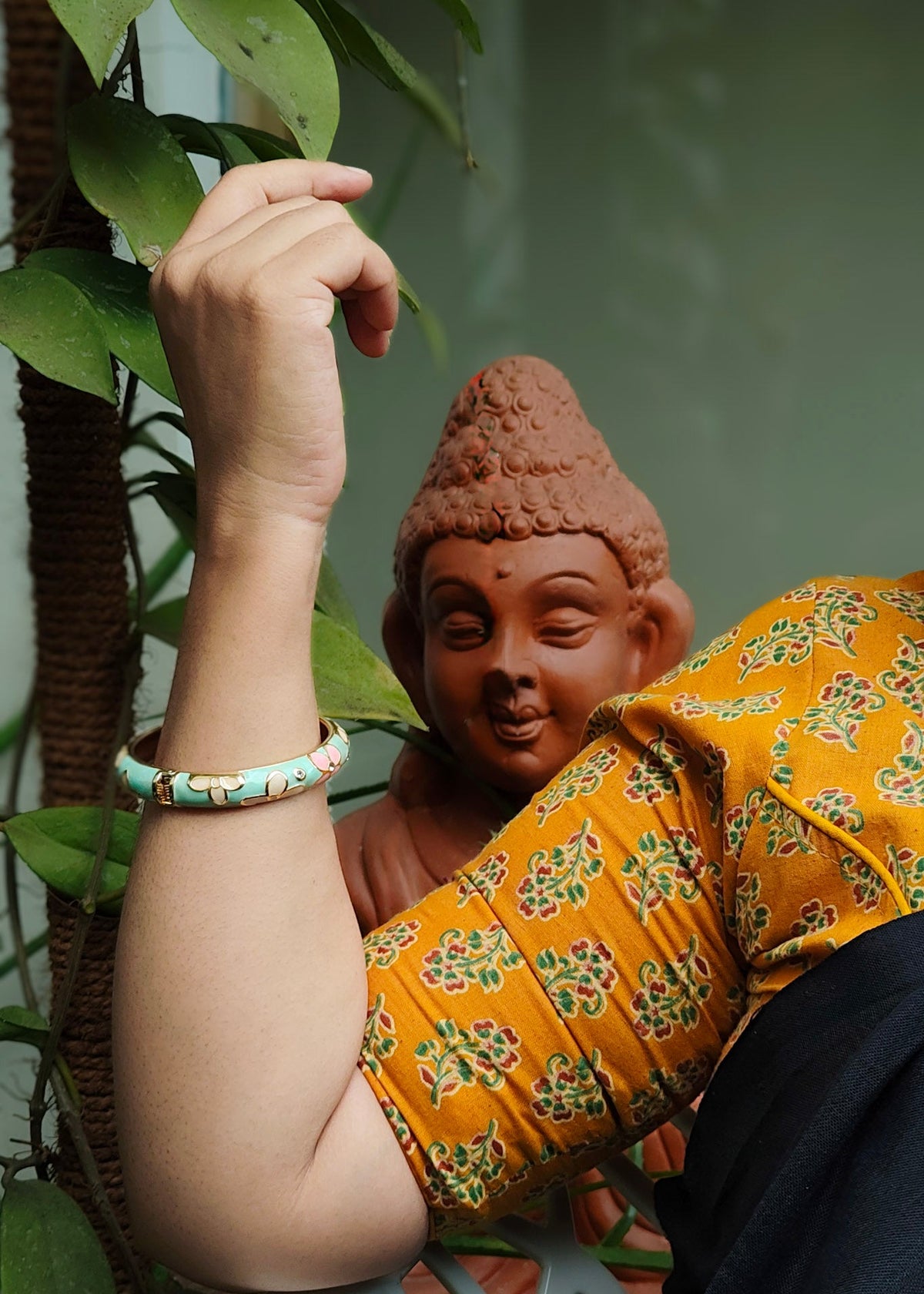  a person wearing a light green beaded bracelet,