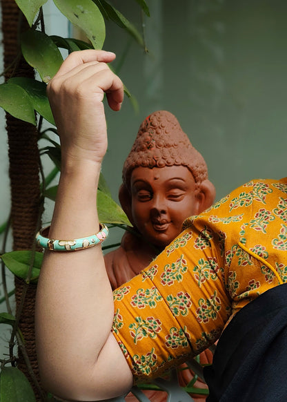  a person wearing a light green beaded bracelet,