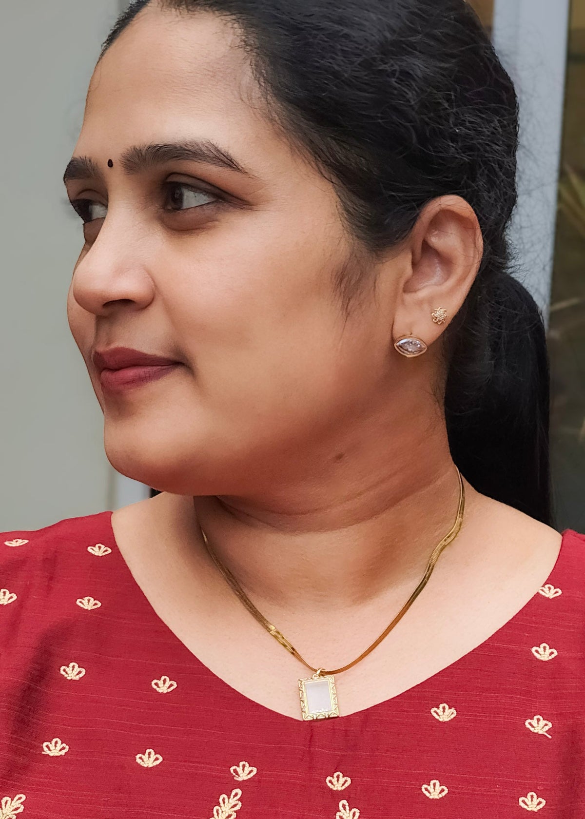 A close-up portrait of a woman wearing a  gold anti tarnish necklace, 