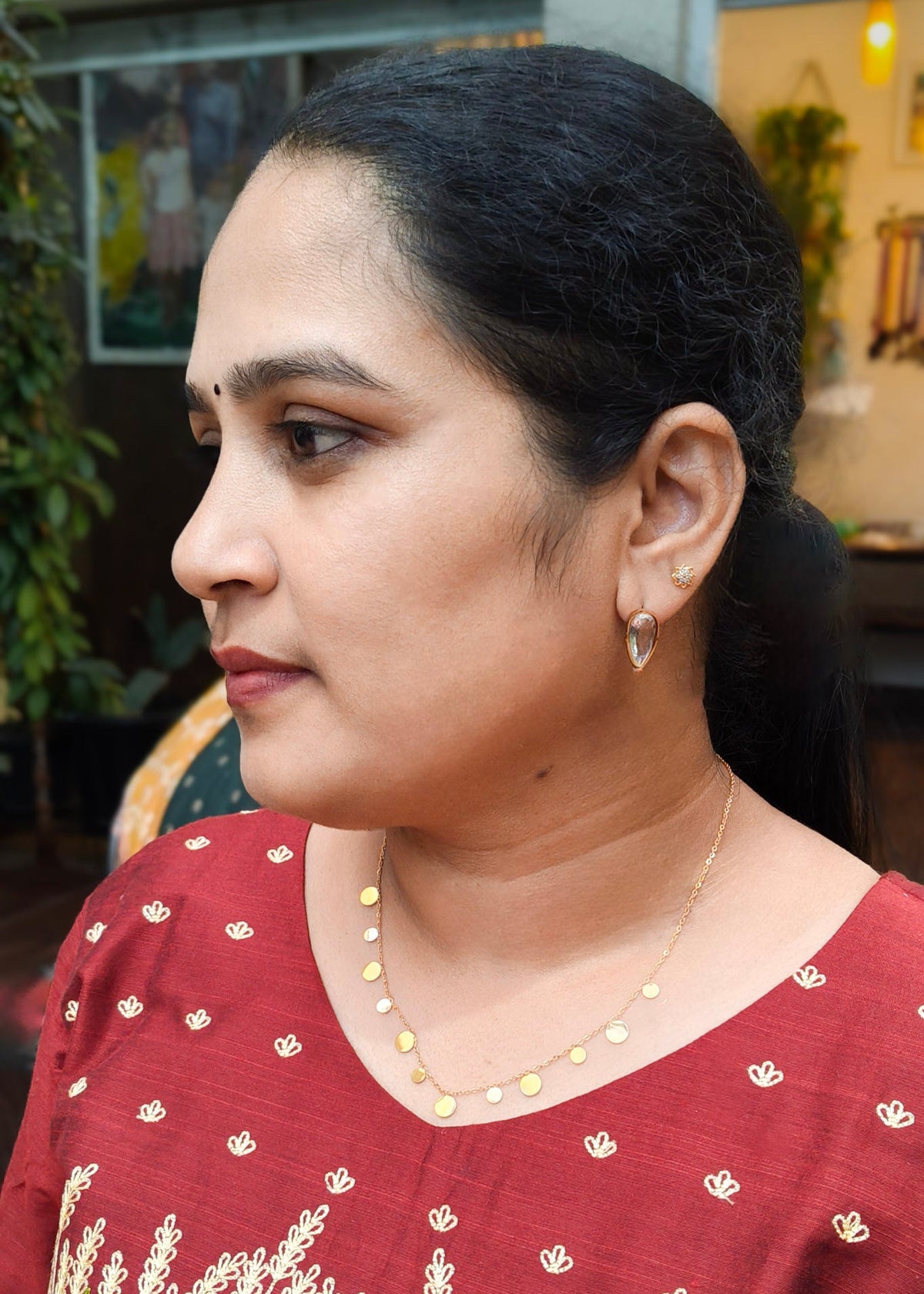 A woman in profile wearing a small gold motifs decorated anti-tarnish necklace
