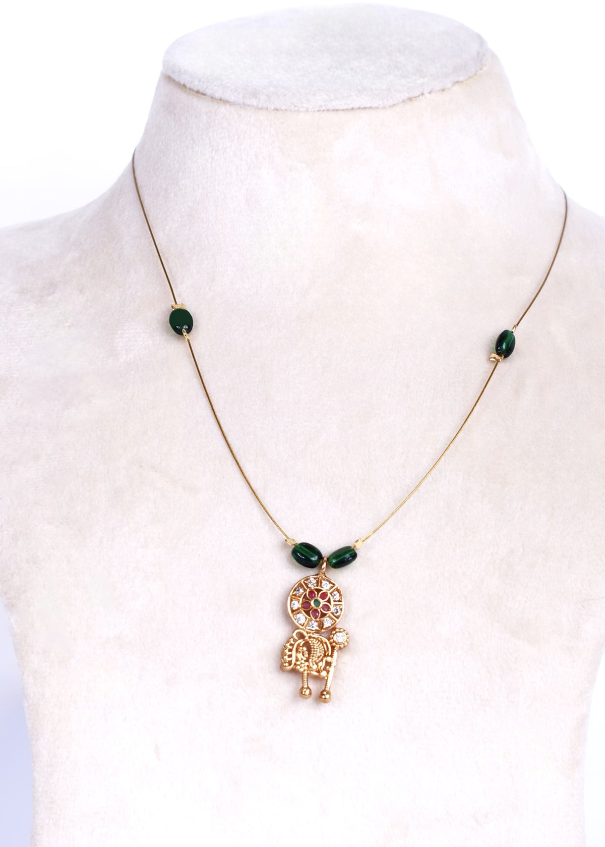 Avani fine-wire necklace with green beads and a floral mandala and elephant pendant on a white display.