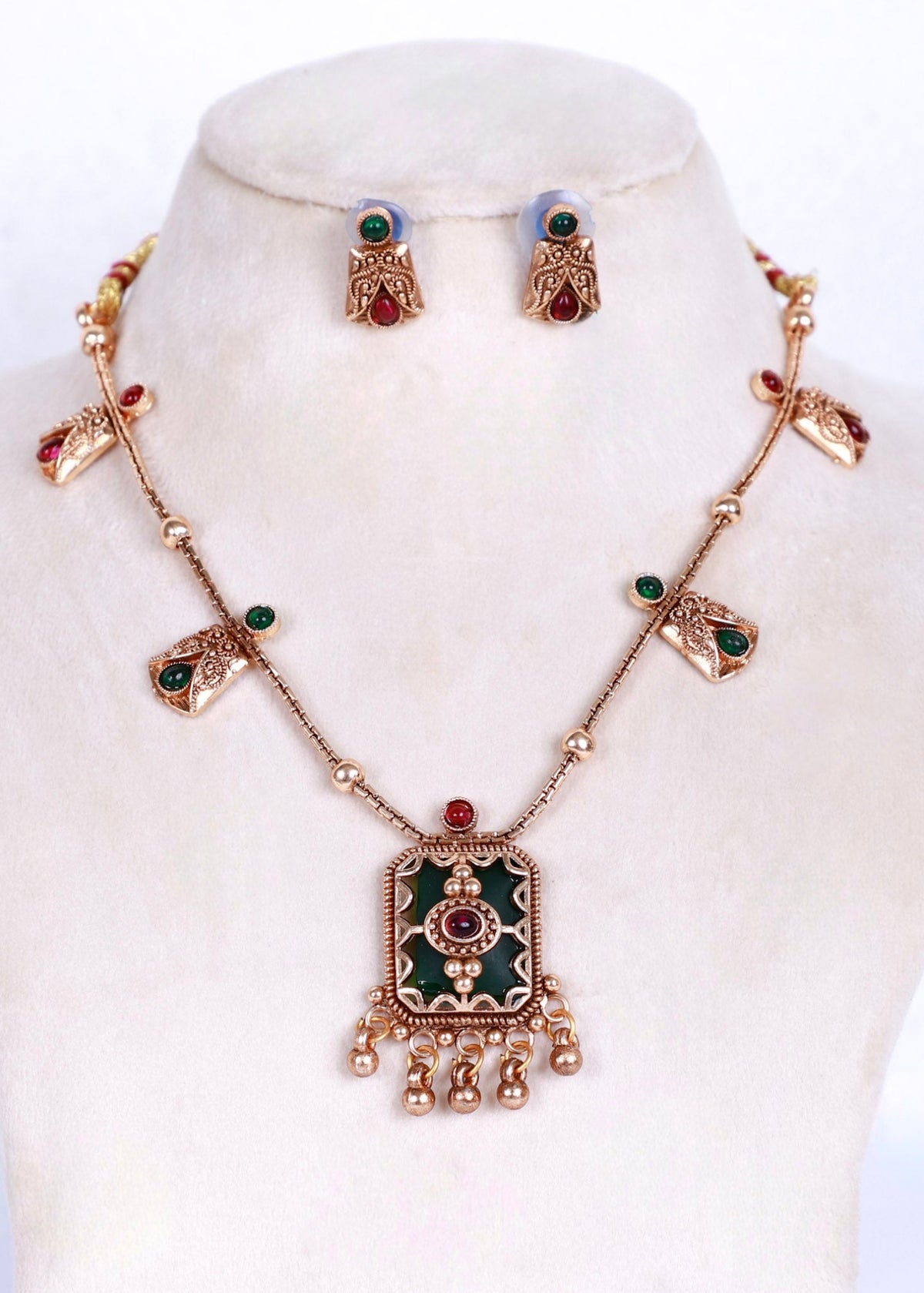Antique type gold plated necklace set with green and red stone embellishments with green enamel pendant. 