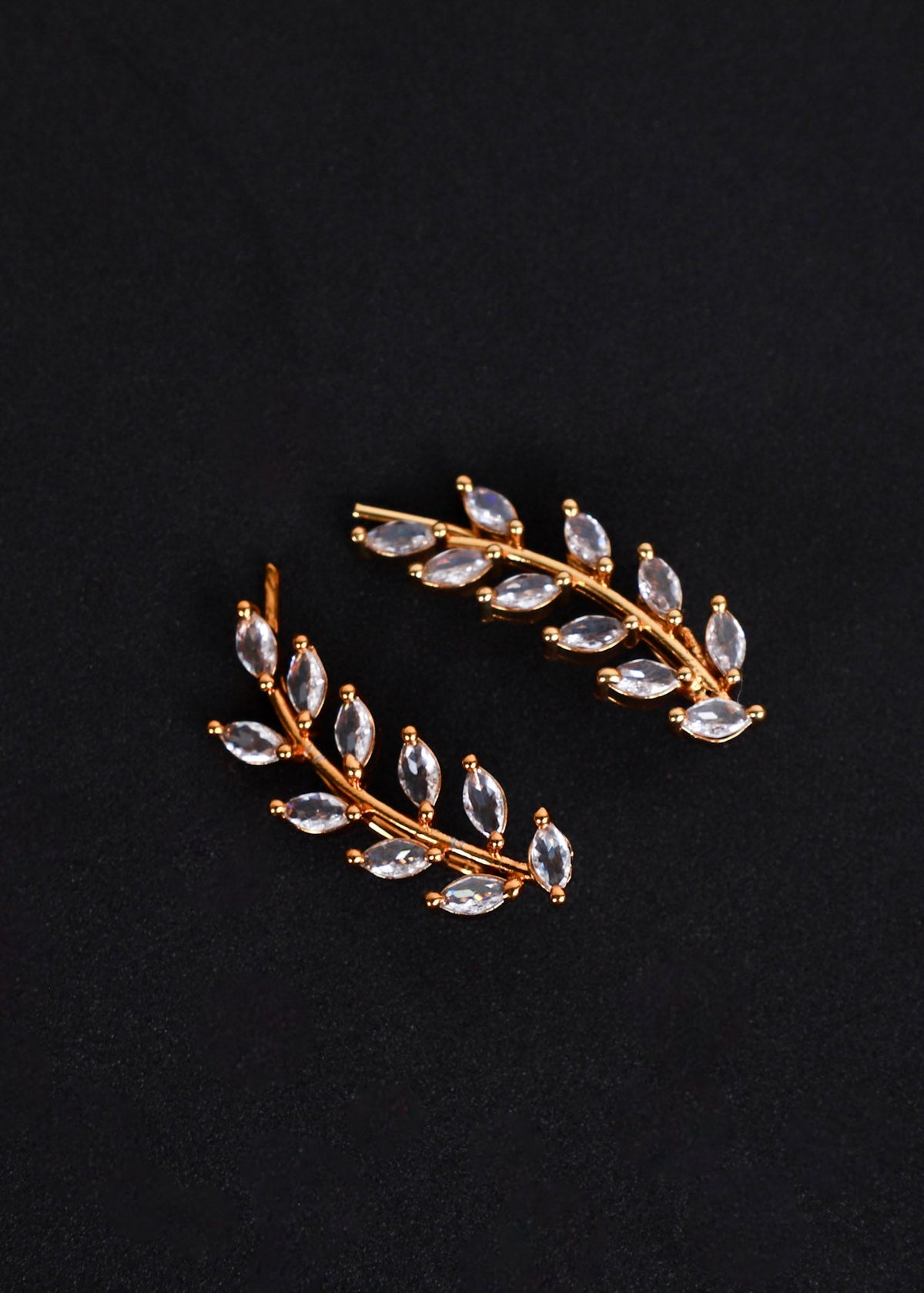 A pair of gold-toned leaf-shaped earrings with marquise-cut clear rhinestones.