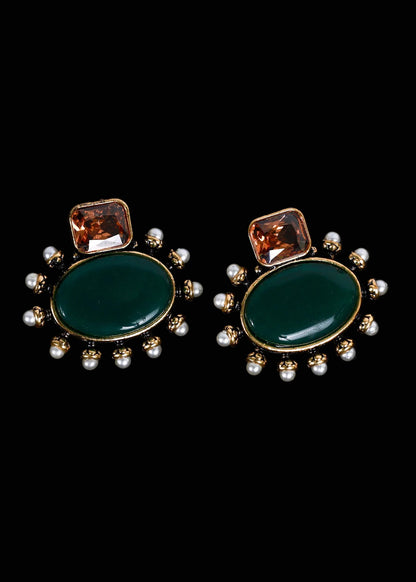 A pair of gold-tone statement earrings featuring a large oval dark green stone, a smaller square amber-brown stone above it, and a border of small white pearls, 