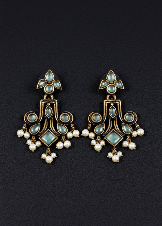 A pair of ornate dangling earrings. The earrings feature antique bronze-toned metalwork with pale blue-green stones and small white pearl drops.