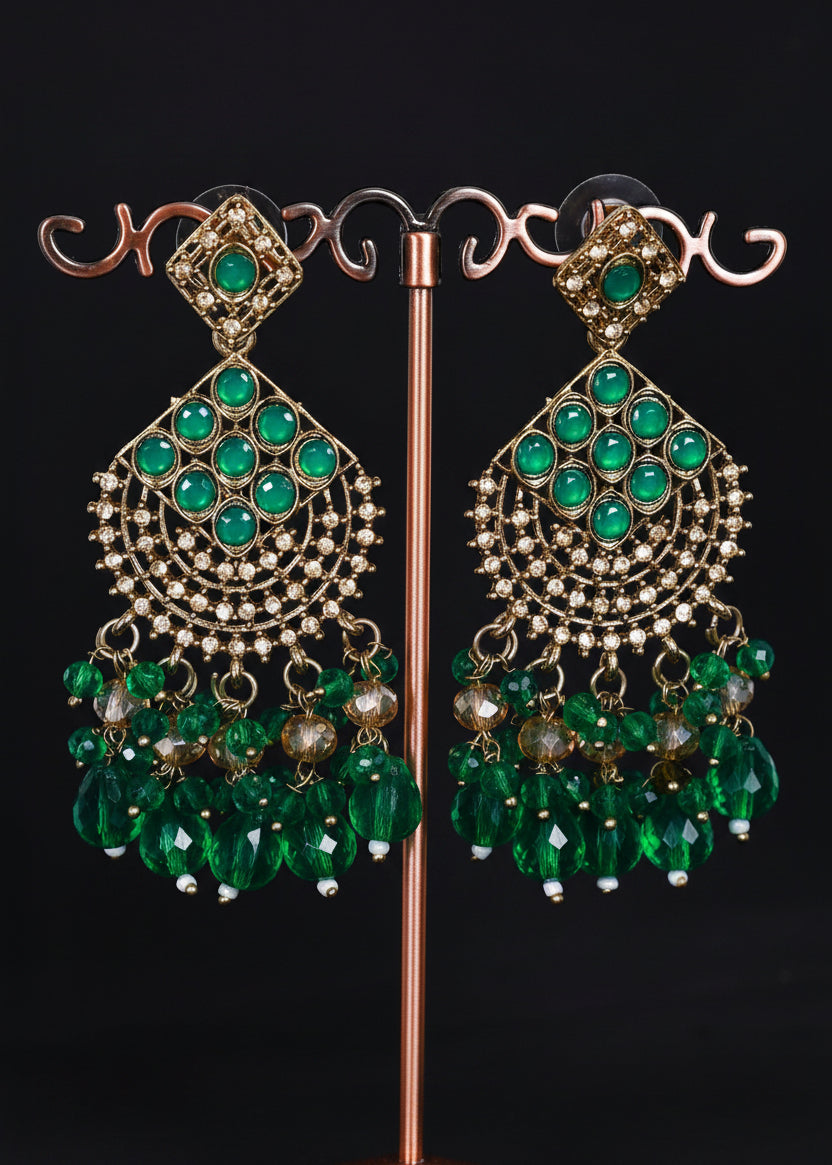 A pair of ornate gold-toned statement earrings with multiple rows of green stones and dangling green bead clusters.