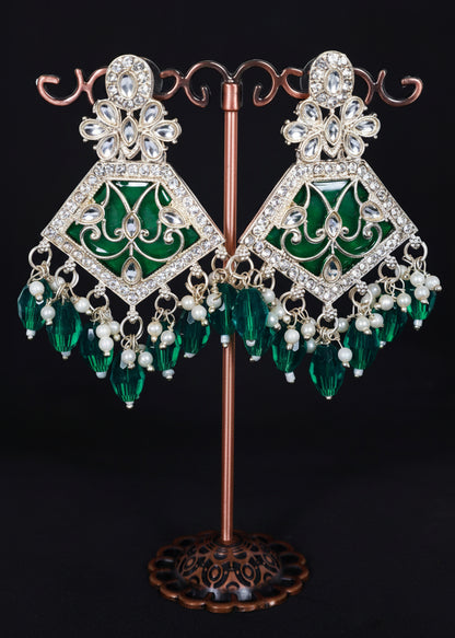 A pair of ornate gold-plated dangle earrings with green enamel panels, clear rhinestone embellishments, and dangling green crystal beads.