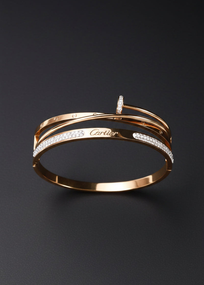 A gold-tone Cartier bangle bracelet with pavé-set clear stones, displayed on a black velvet jewelry box against a dark background.