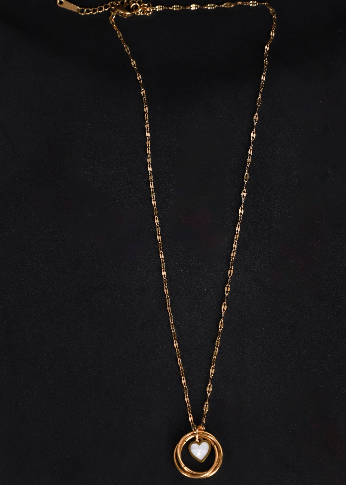 Afreen gold-toned heart and ring necklace on a black background, showing the textured chain and extension clasp.