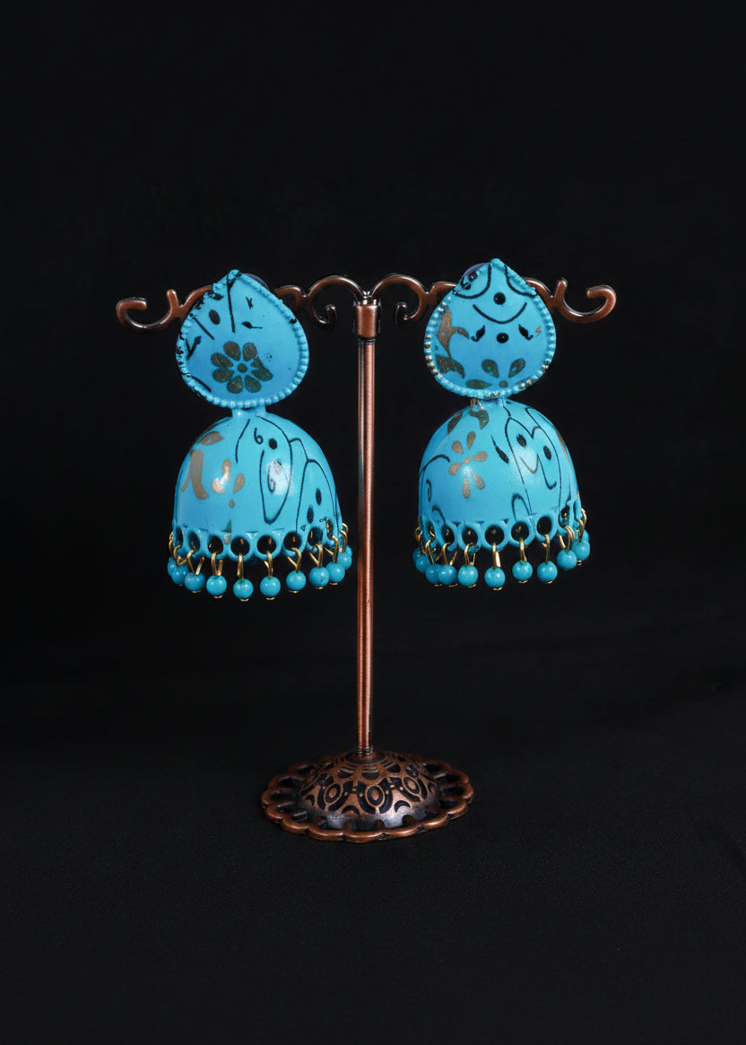 A pair of turquoise blue decorative pendant lamps with floral cutout details and dangling bead fringes.