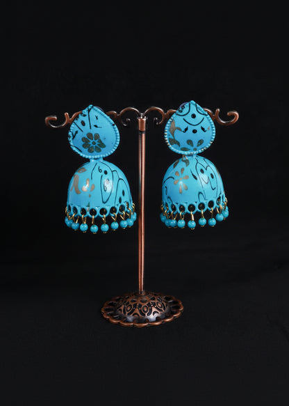 A pair of turquoise blue decorative pendant lamps with floral cutout details and dangling bead fringes.