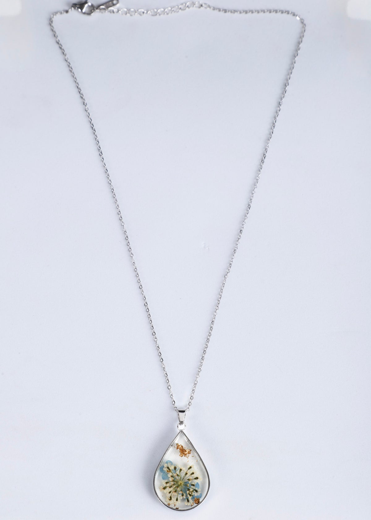 Anti tarnish silver teardrop pendant necklace featuring a preserved butterfly and dandelion inside, displayed on a white background.