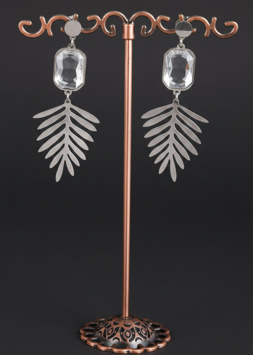 A pair of silver-toned dangle earrings with rectangular clear stones and leaf-shaped drops.