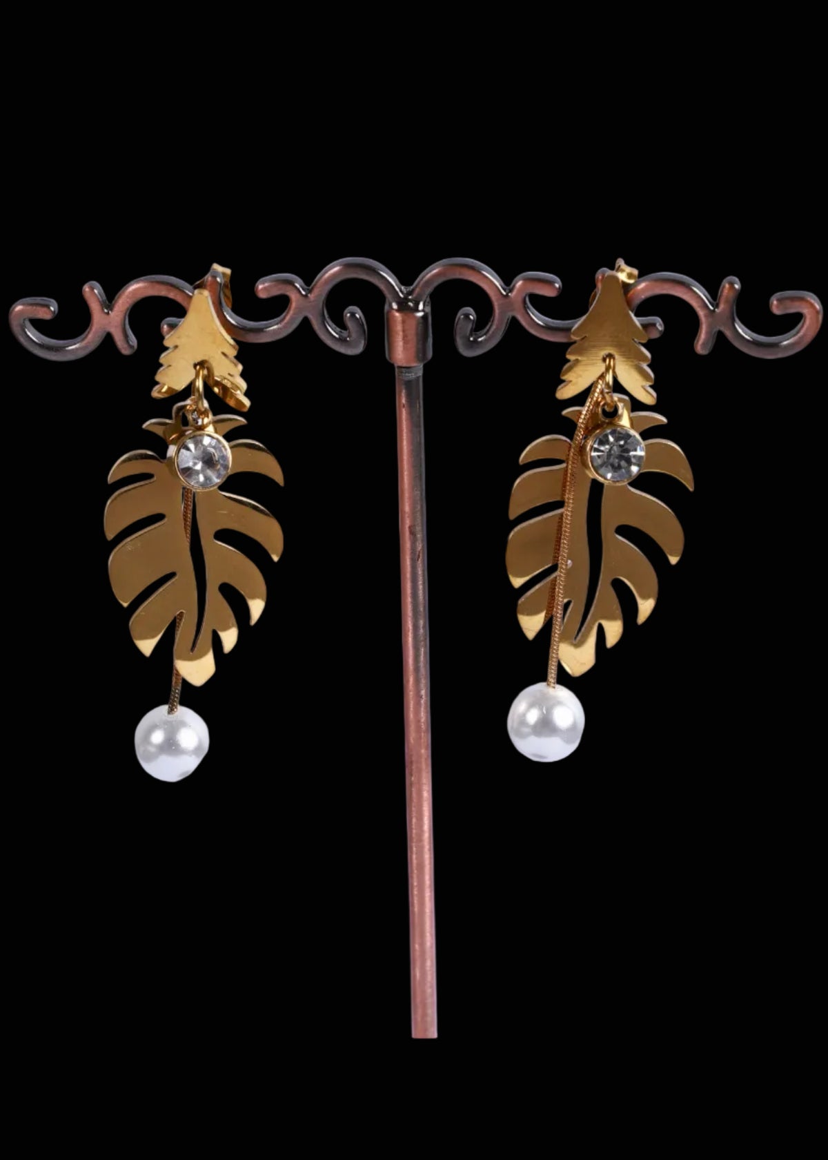 A pair of gold-toned dangle earrings. Each earring features a leaf-shaped gold pendant with a small clear rhinestone and a dangling white pearl.