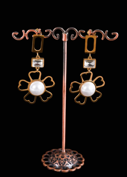 A pair of gold-tone drop earrings with rectangular clear rhinestones and large white pearl flower-shaped dangles.