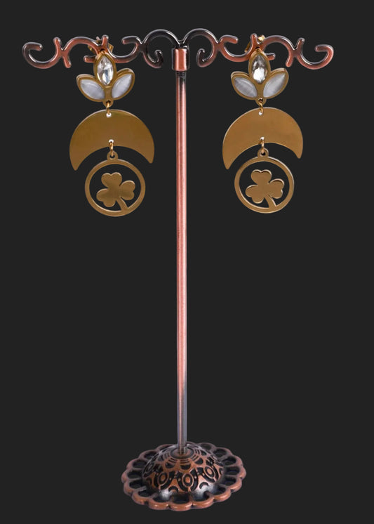 A pair of anti-tarnish gold dangling earrings. The earrings feature a gold crescent moon and clover design with small white and clear stones at the top.